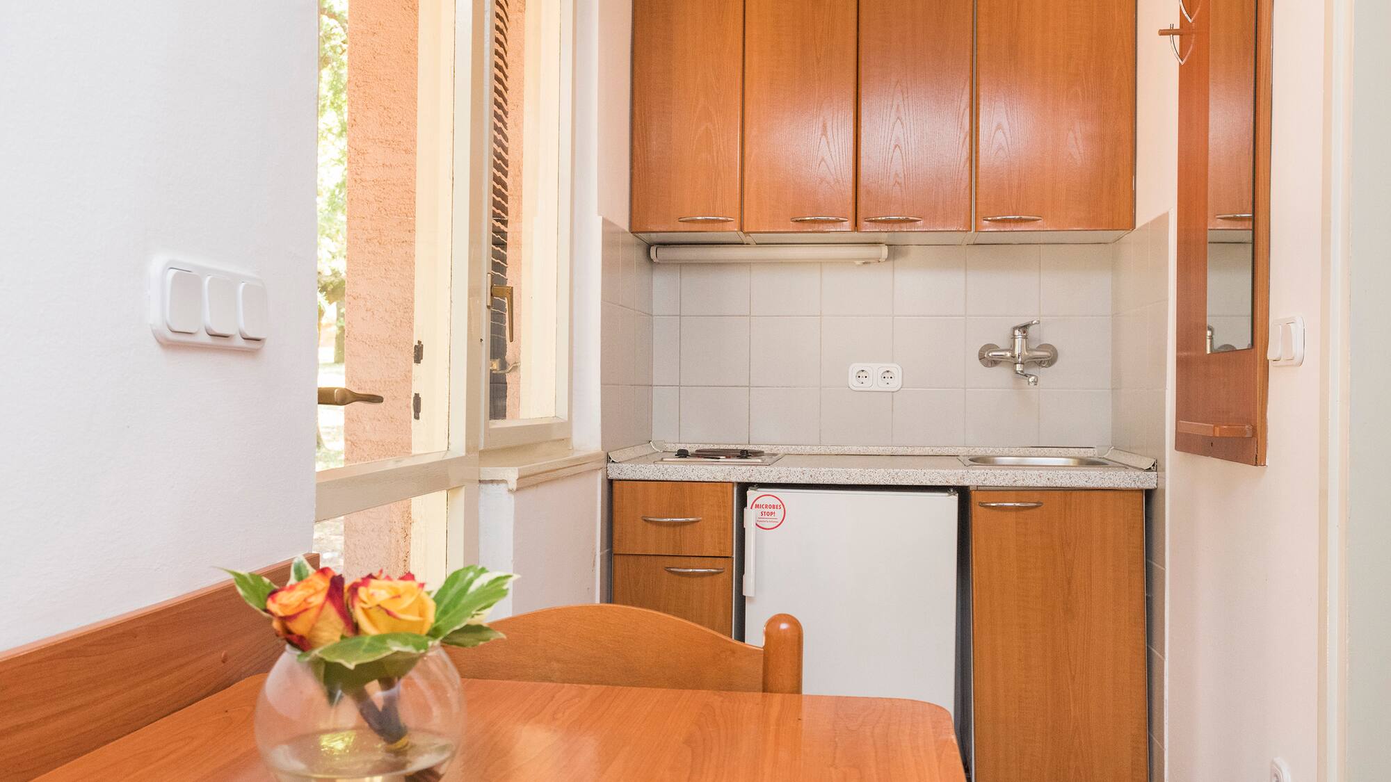 a kitchen with a table and a vase of flowers