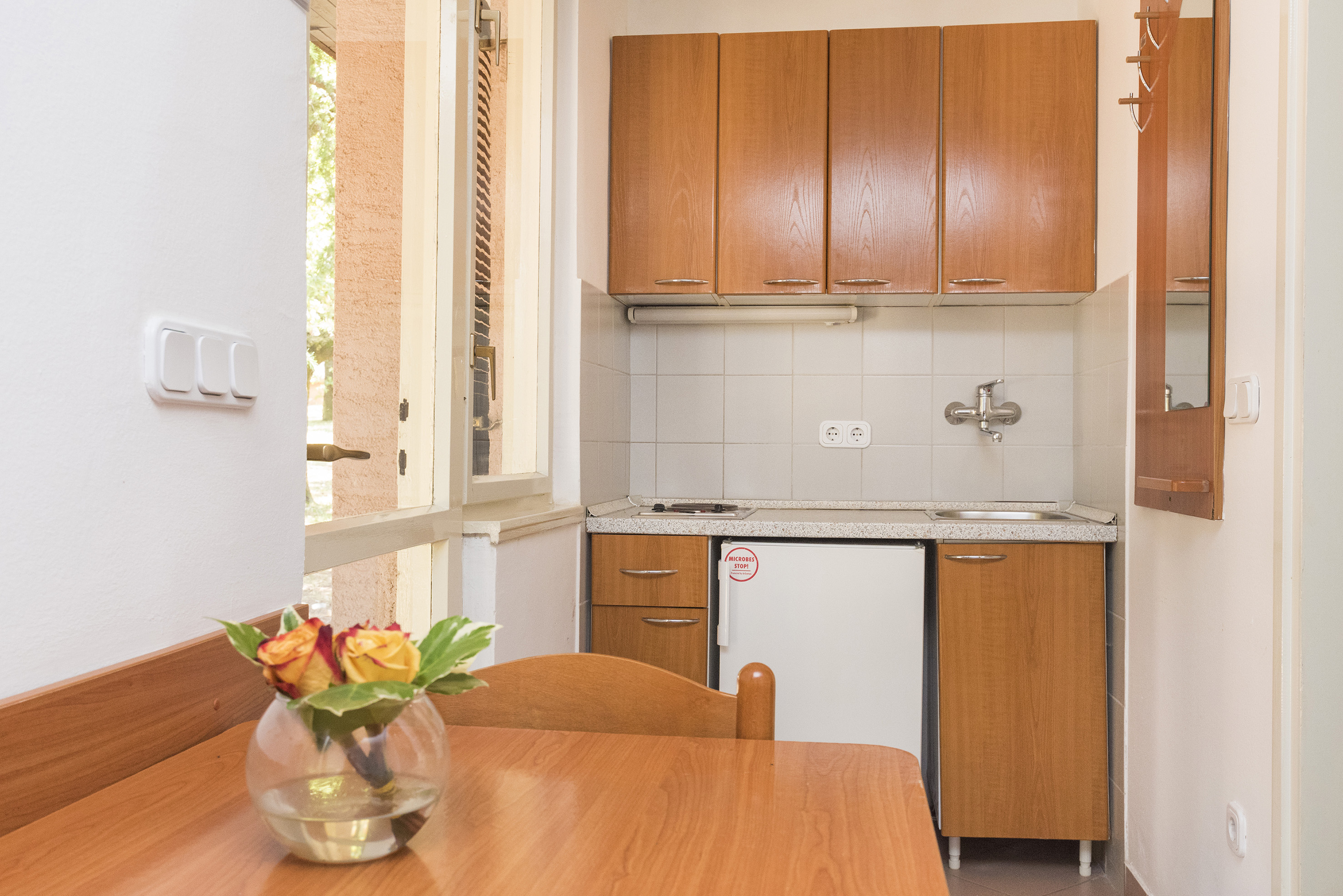 a kitchen with a table and a vase of flowers
