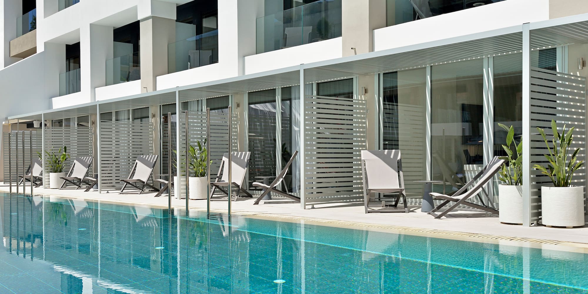 a pool with chairs and a building