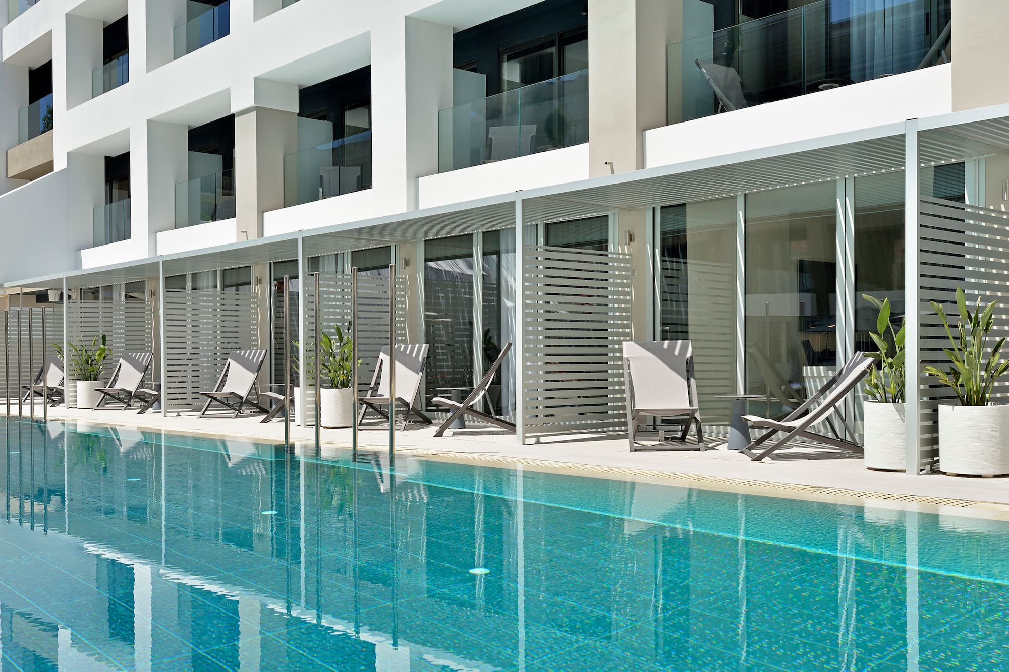 a pool with chairs and a building