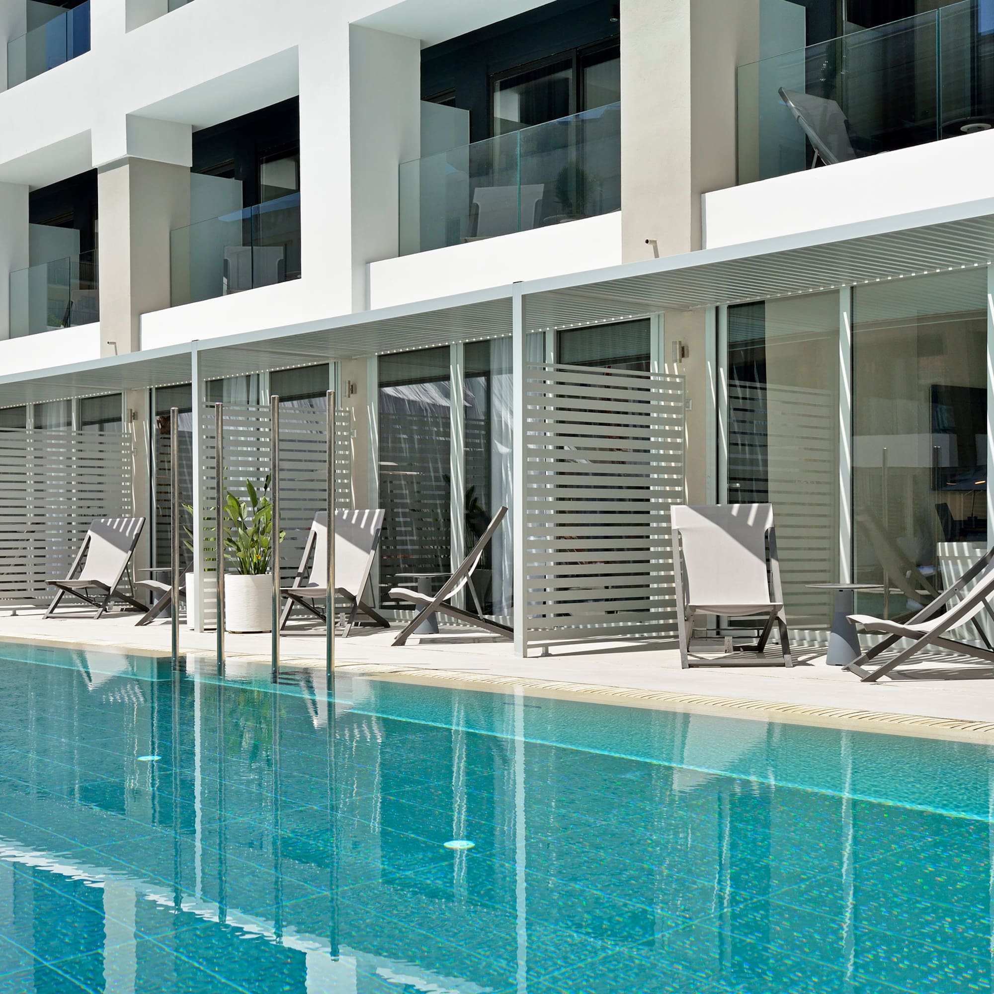 a pool with chairs and a building