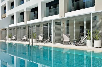 a pool with chairs and a building
