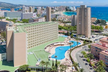 a large building with a pool and buildings by the water