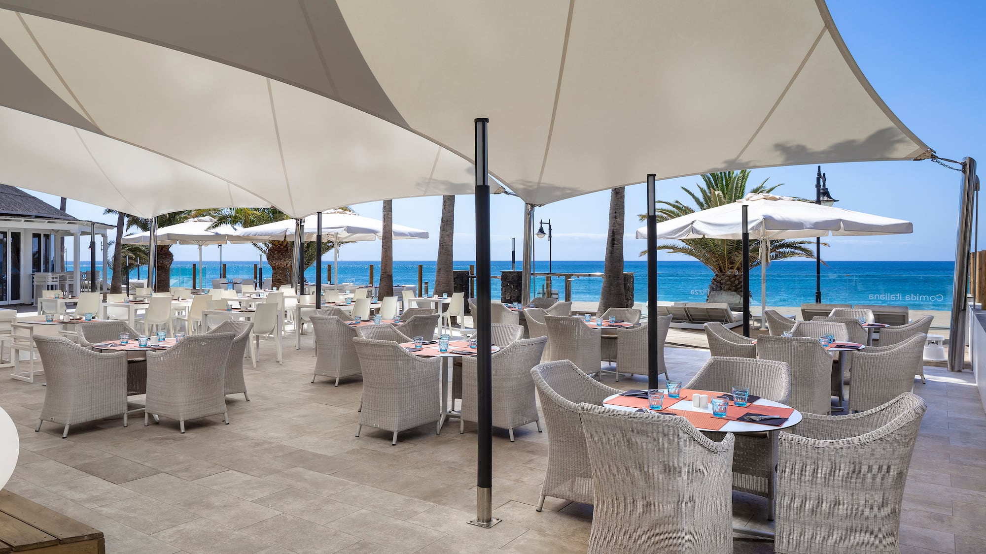 a restaurant with tables and umbrellas