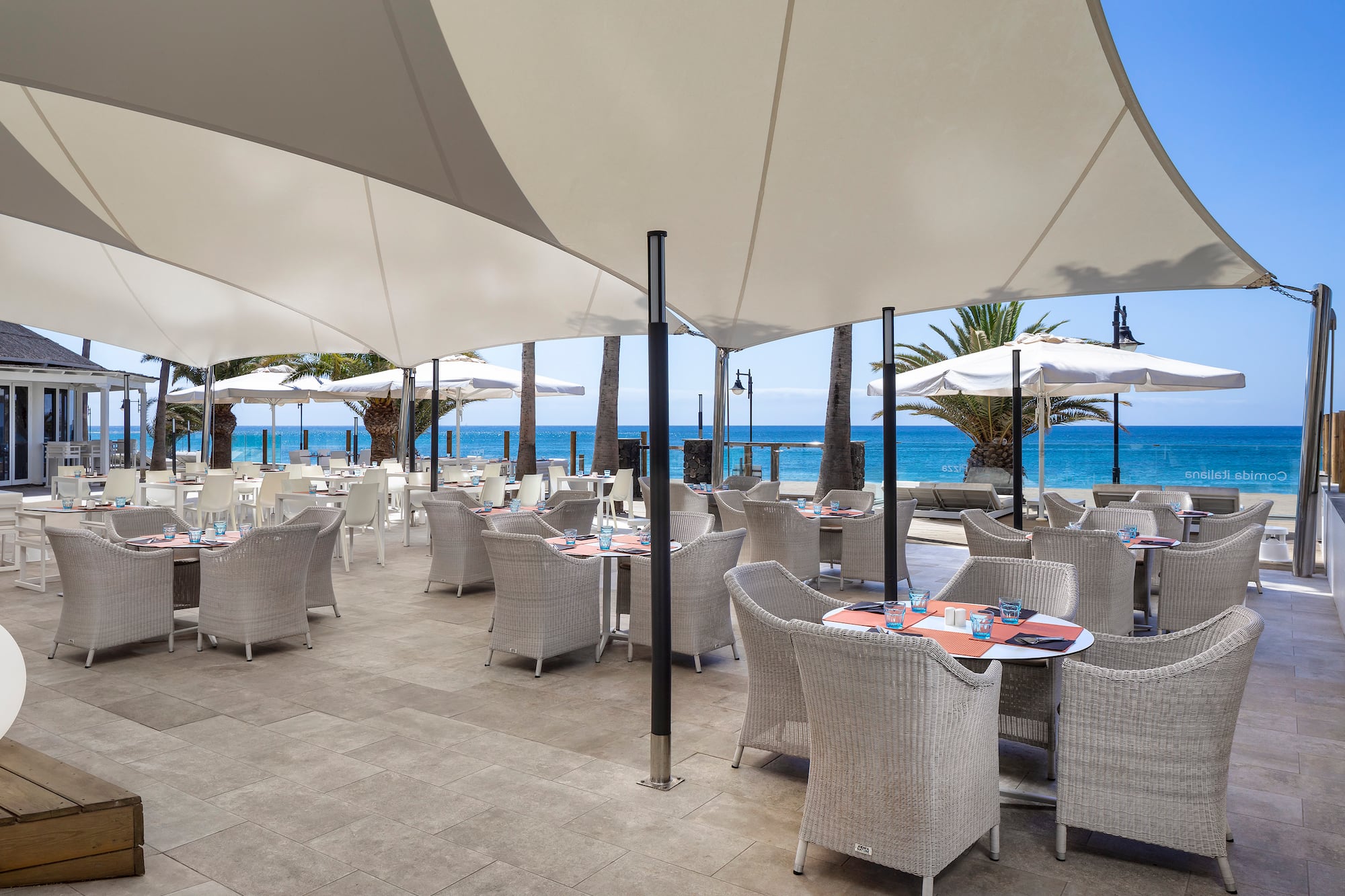 a restaurant with tables and umbrellas