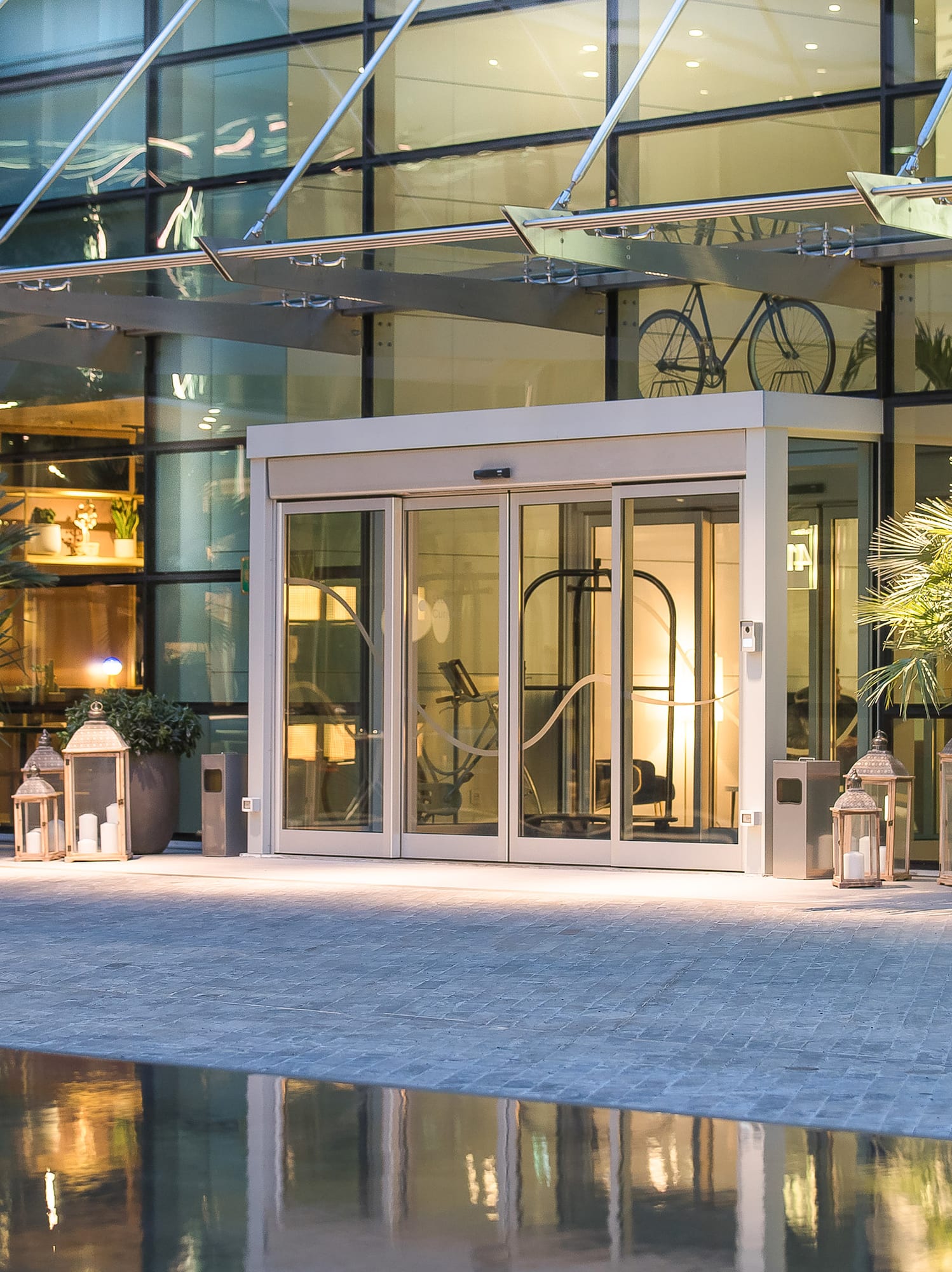 a glass building with a pool and a glass door
