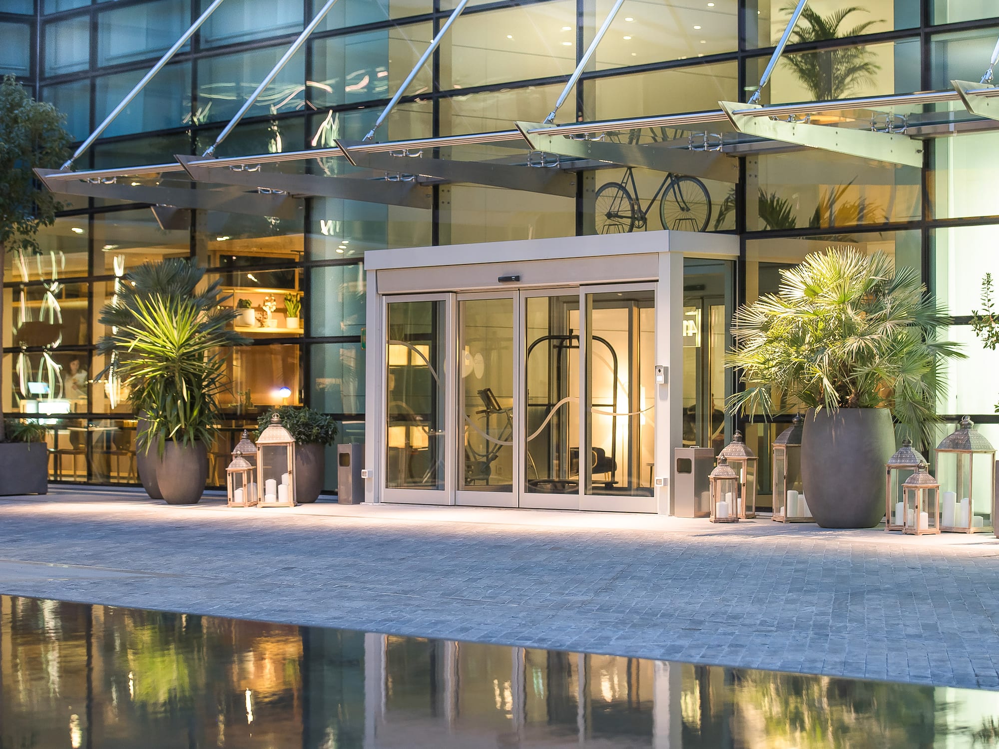 a glass building with a pool and a glass door