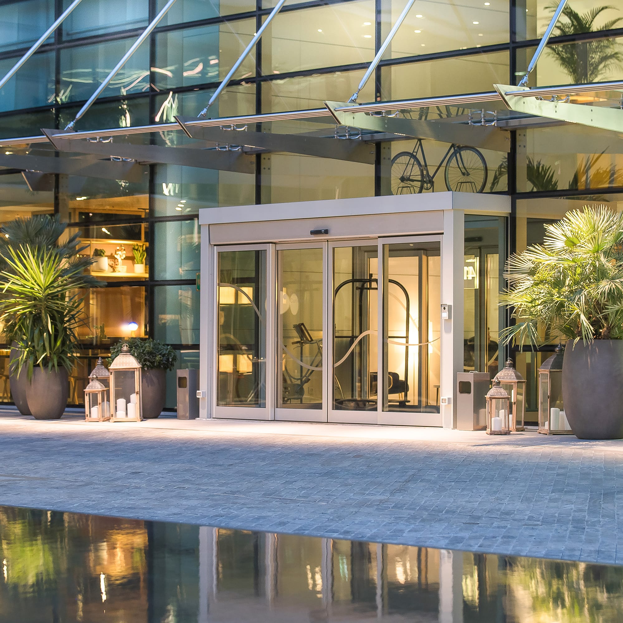 a glass building with a pool and a glass door