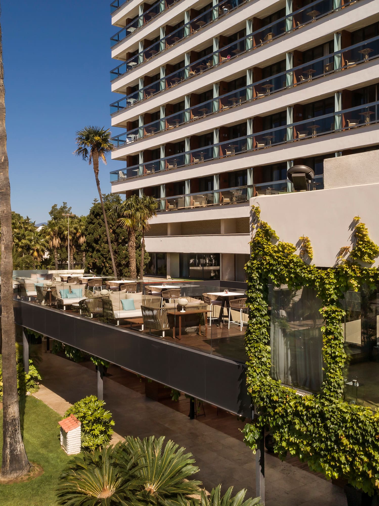 a building with a large white building with trees and plants