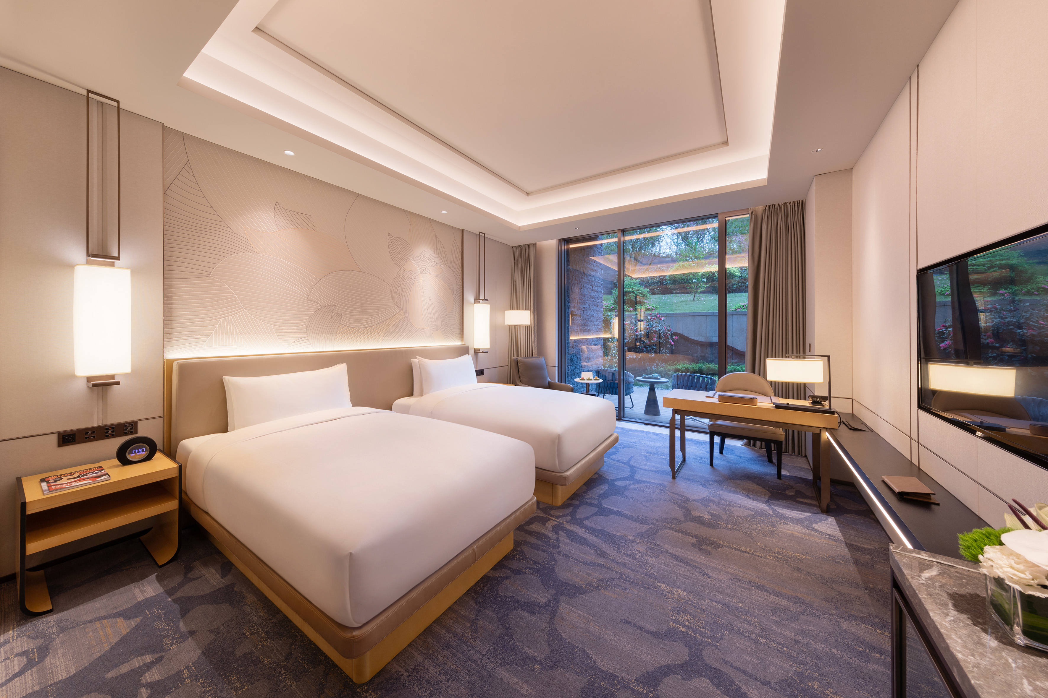 Luxurious modern hotel twin room with two beds, desk, and garden view.