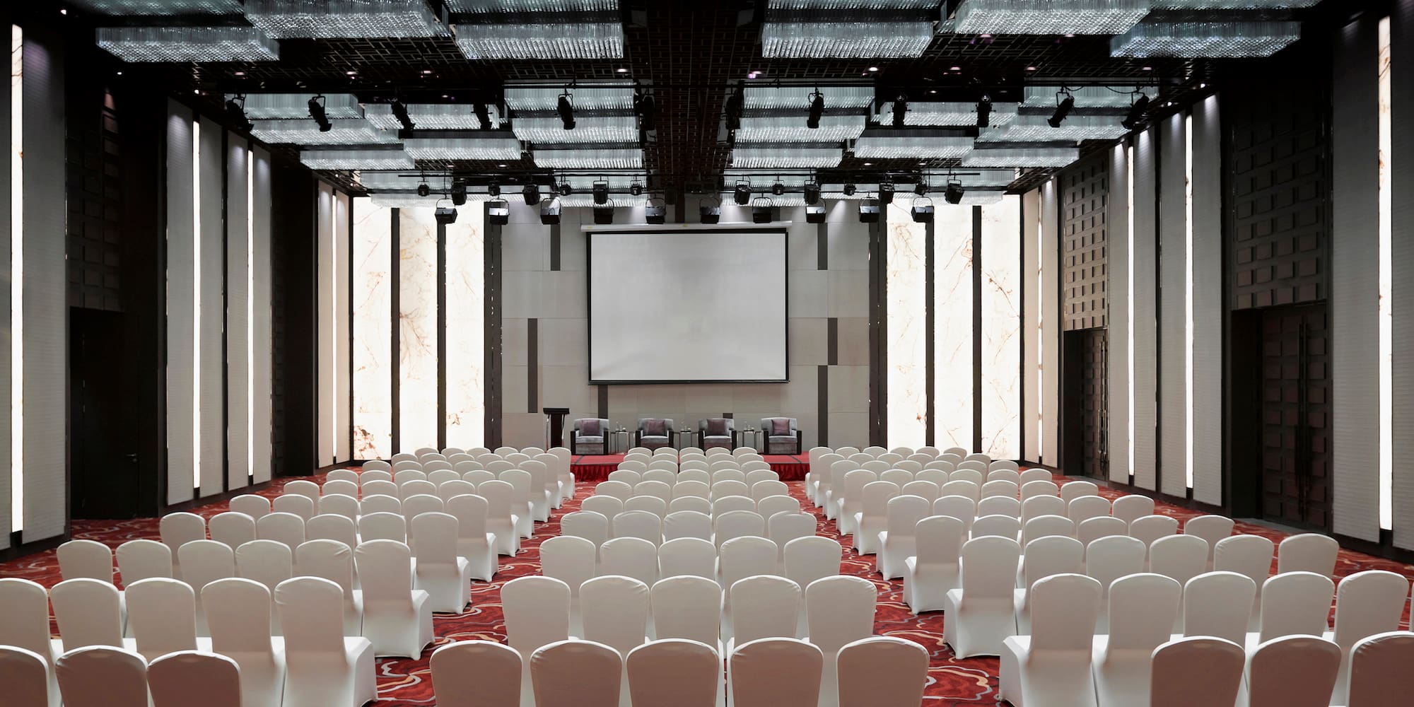 a room with white chairs and a projector screen