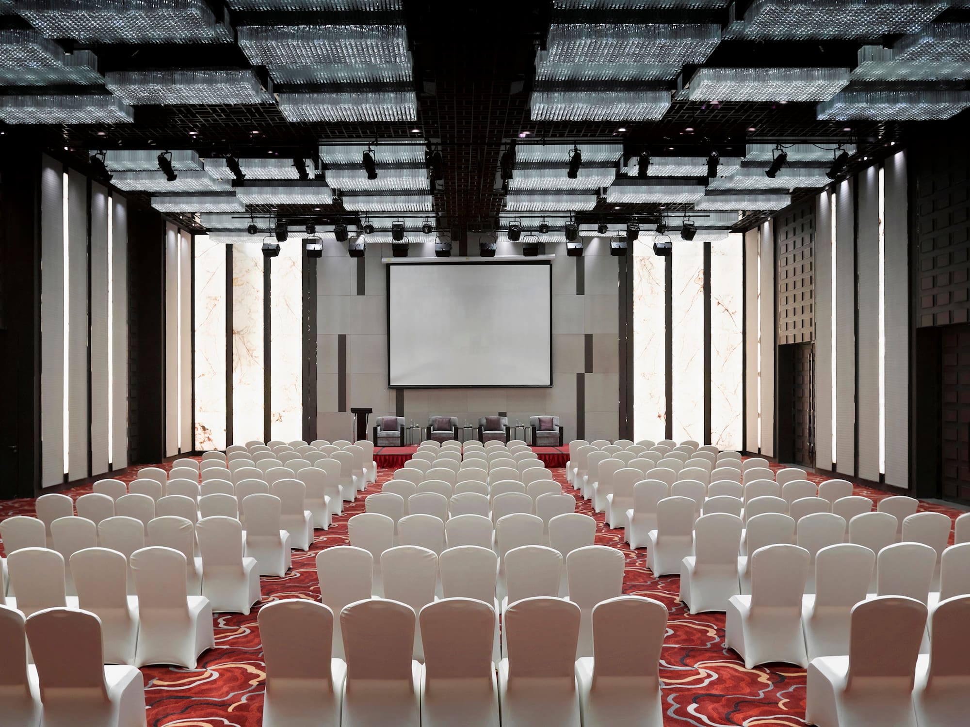 a room with white chairs and a projector screen