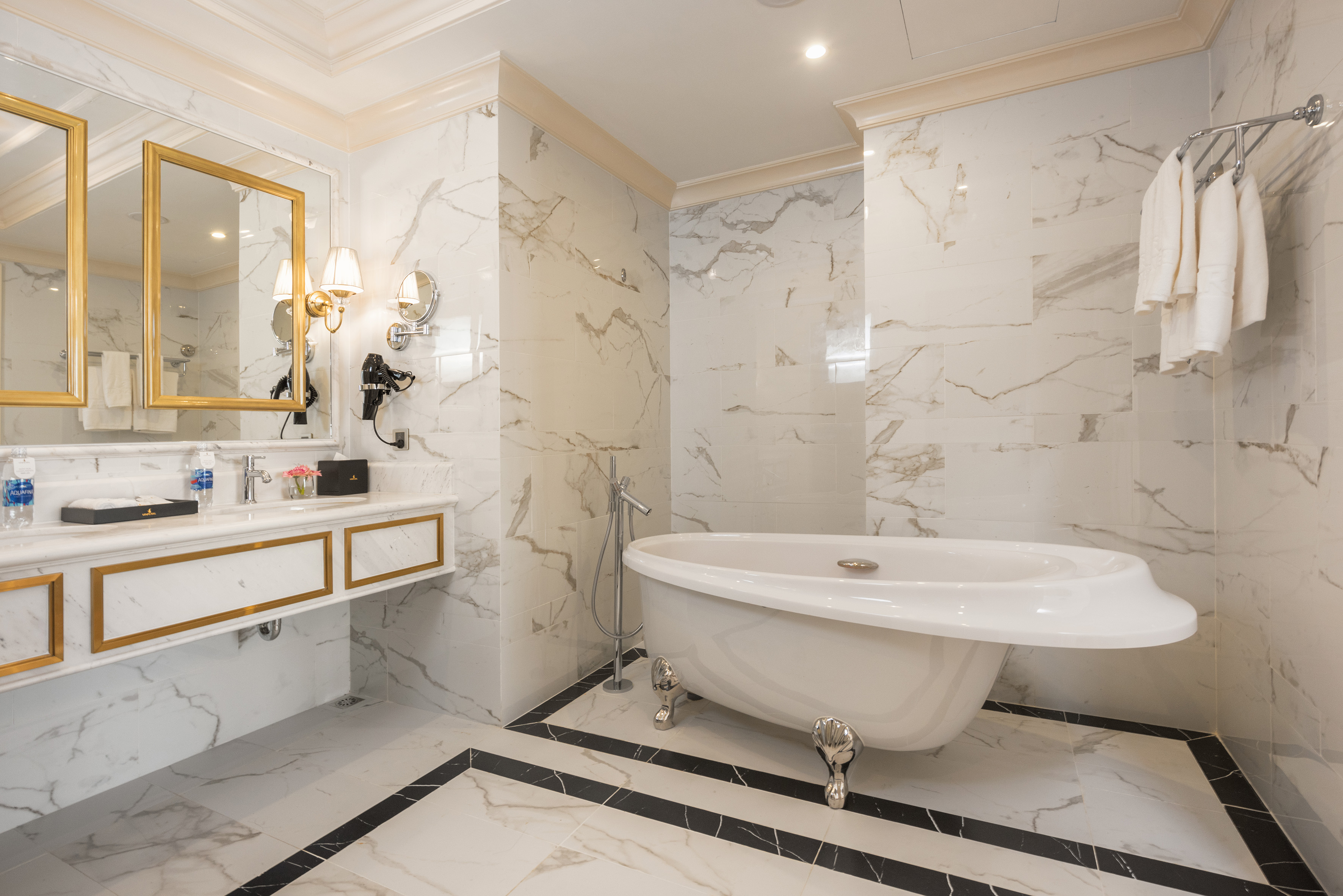 Luxury marble bathroom with freestanding tub, double vanity, and gold accents.