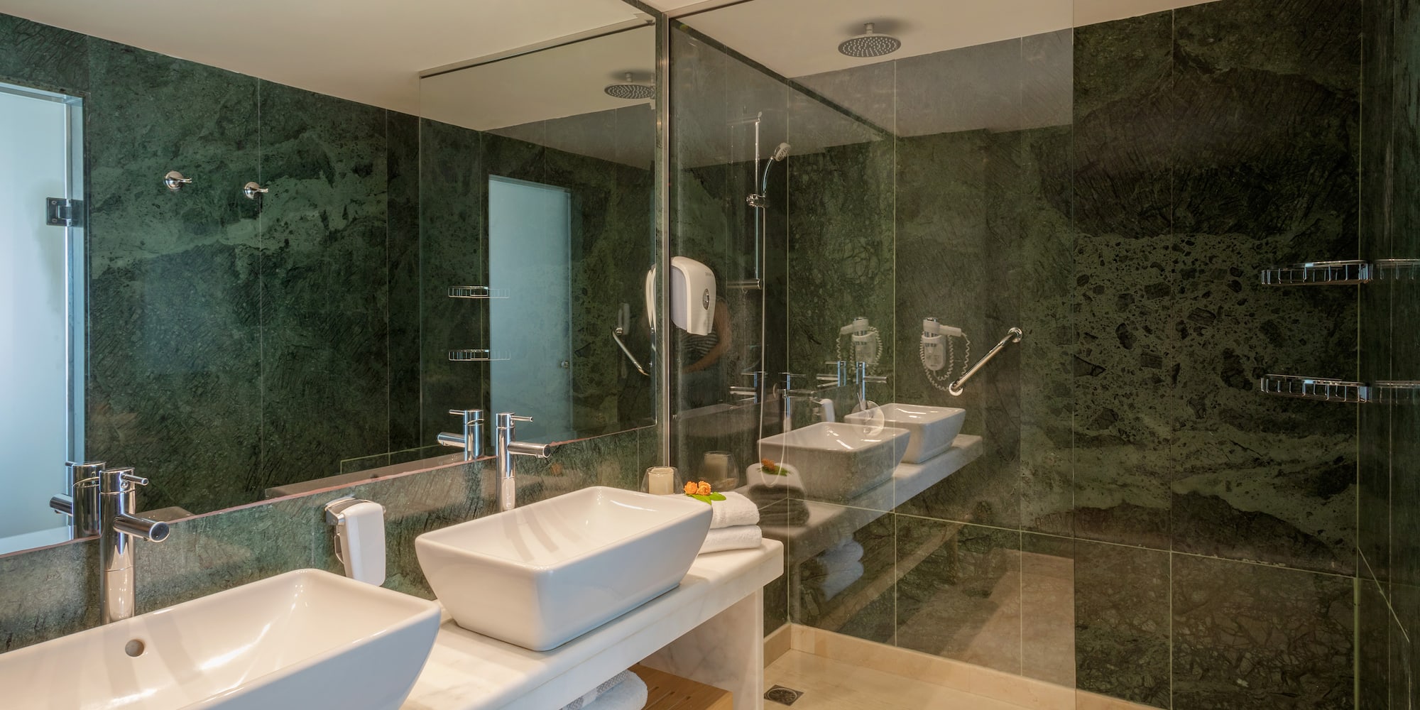 a bathroom with sinks and glass shower doors
