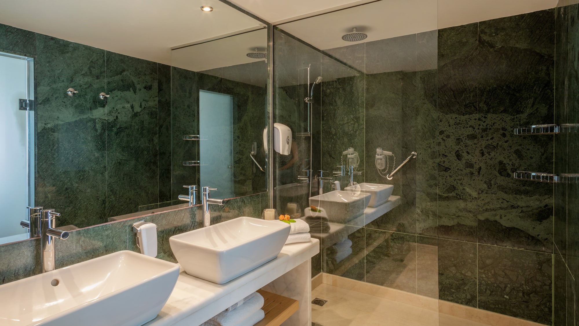 a bathroom with sinks and glass shower doors