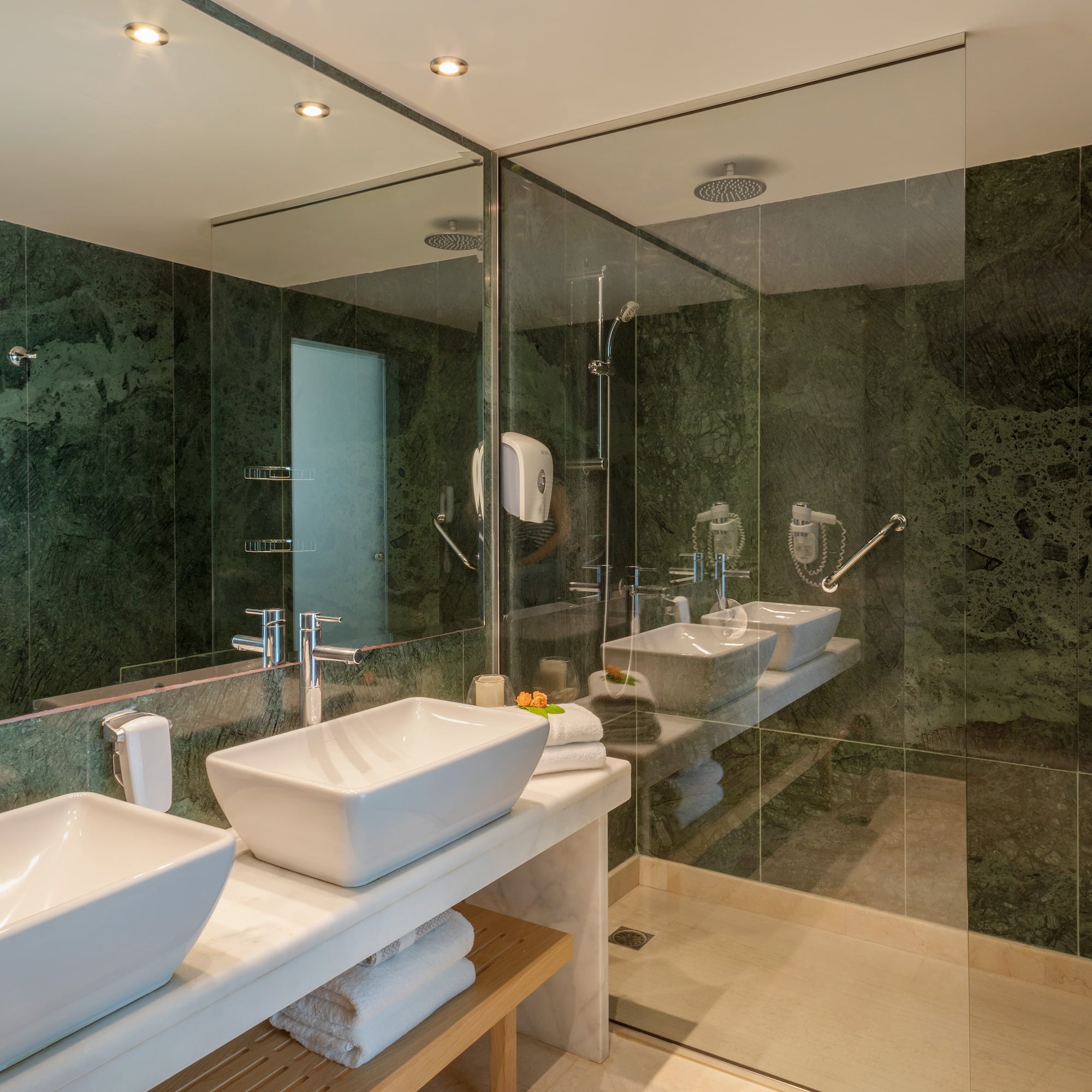 a bathroom with sinks and glass shower doors