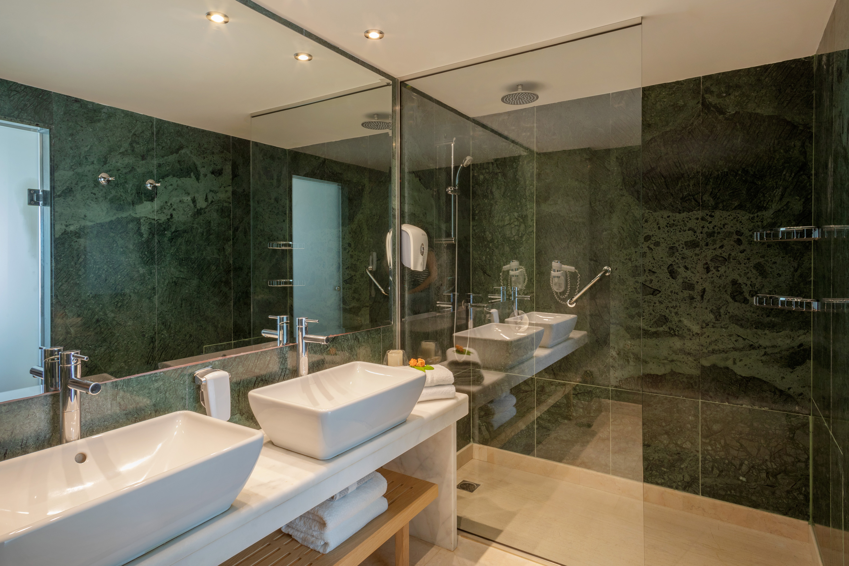 a bathroom with sinks and glass shower doors