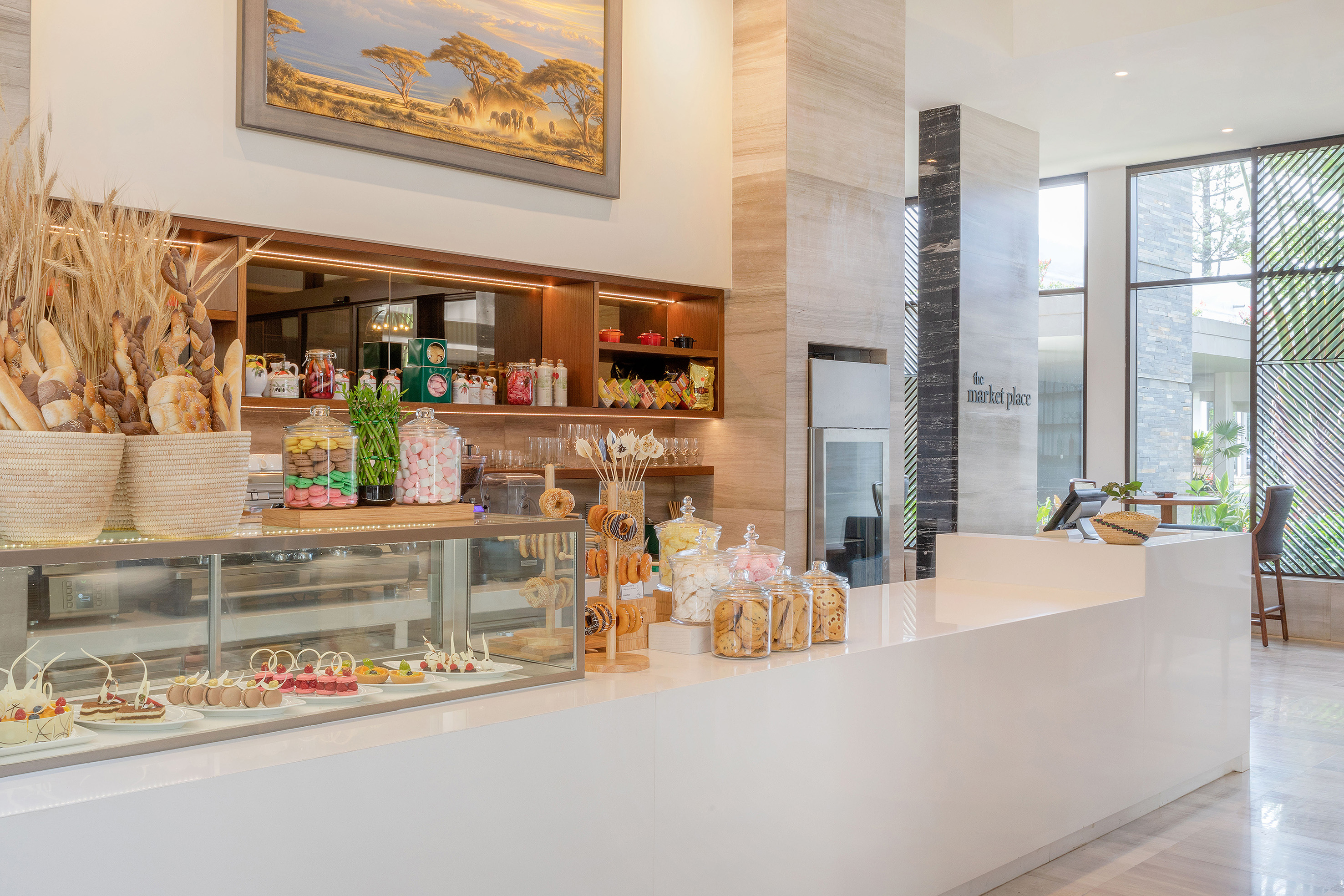 Gourmet bakery display with fresh bread, macarons, and cakes at market place.