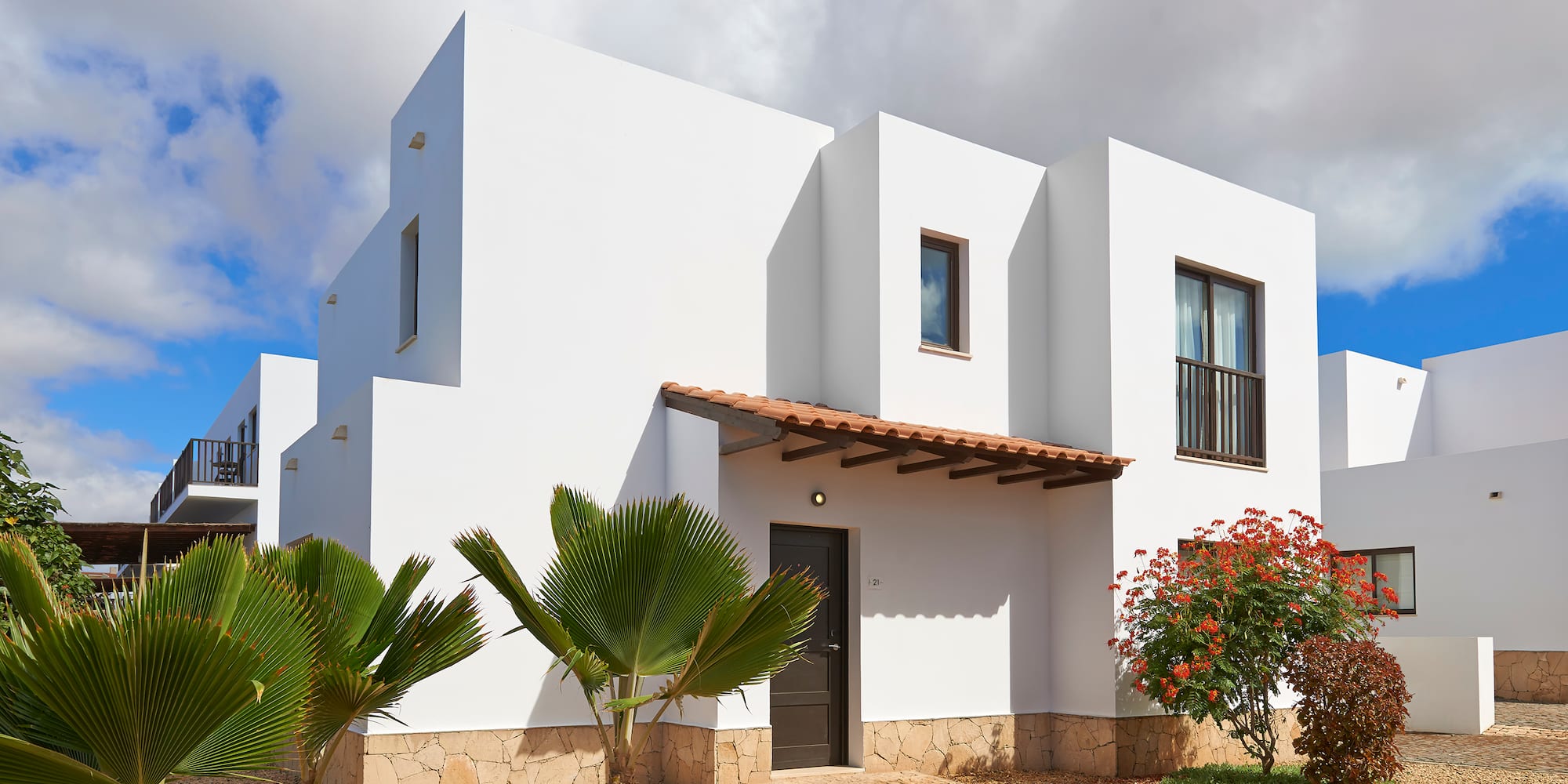 a white house with trees and bushes