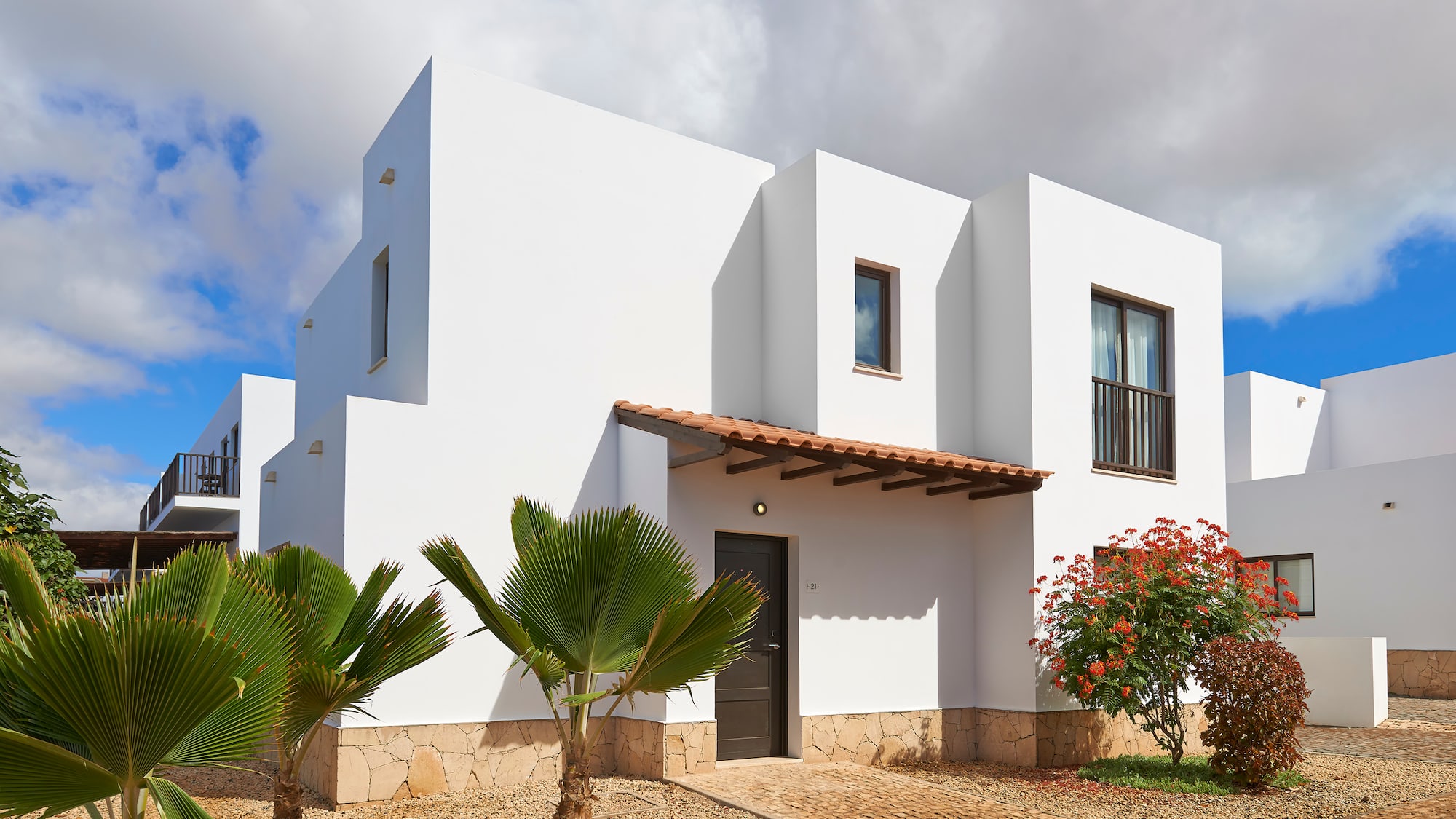 a white house with trees and bushes