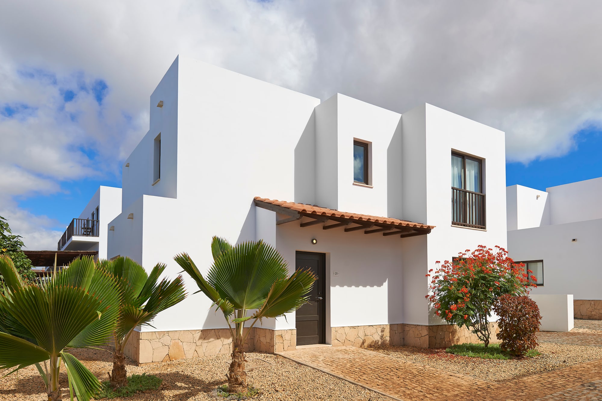 a white house with trees and bushes