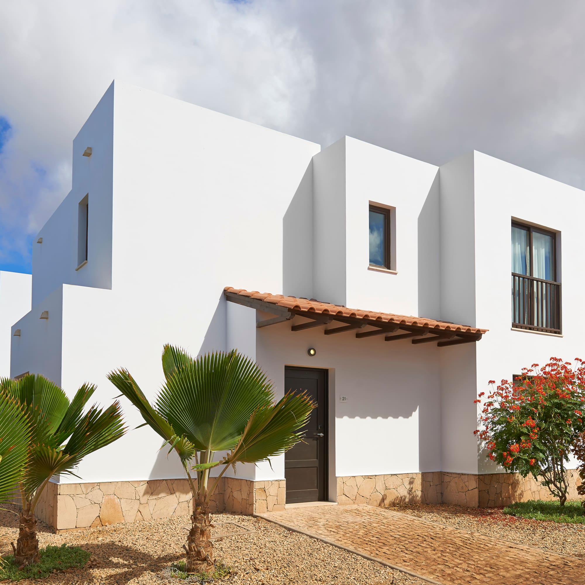 a white house with trees and bushes