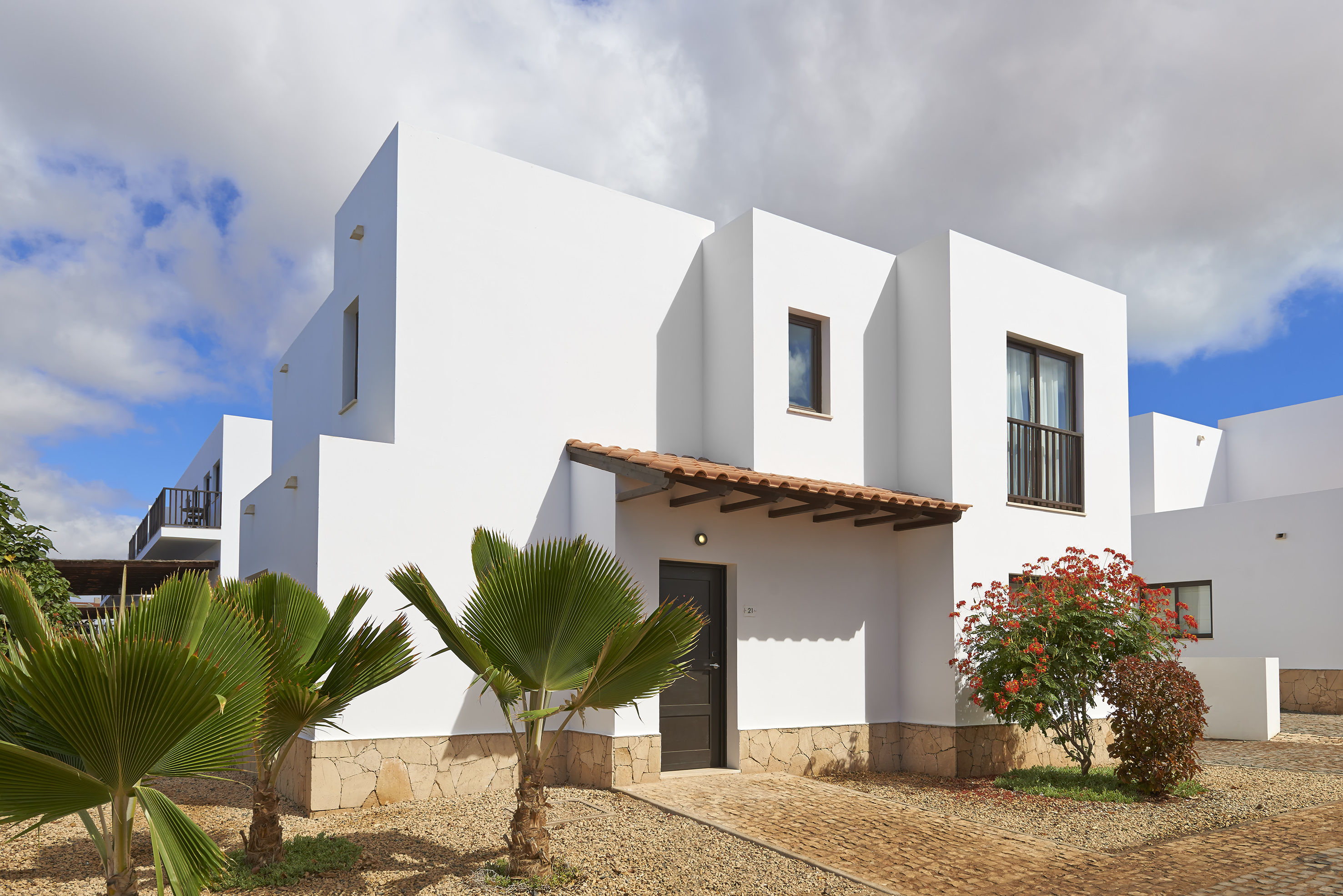 a white house with trees and bushes