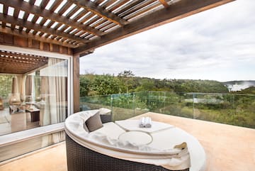 a patio with a round bed and a glass fence