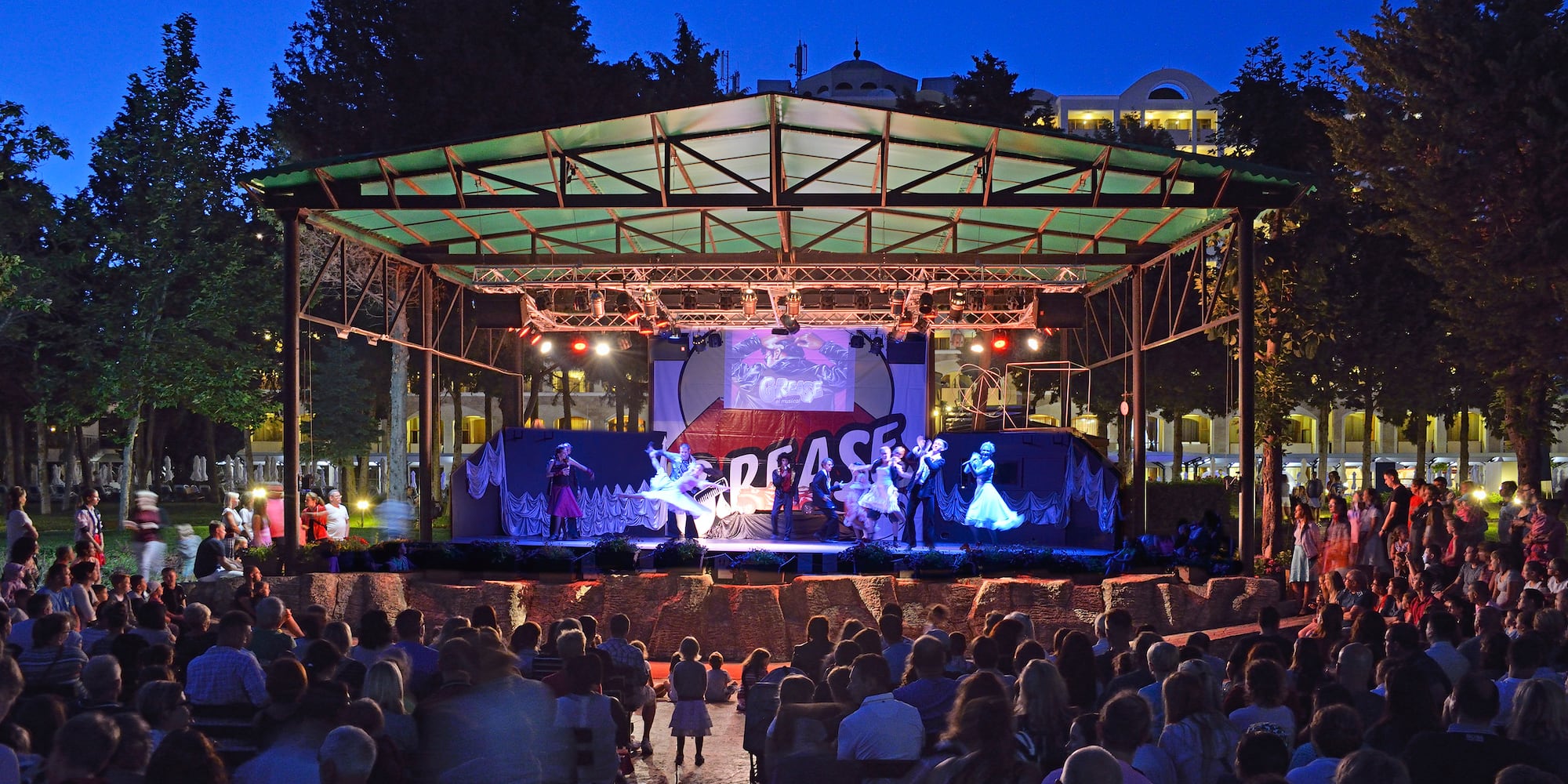 a group of people sitting in front of a stage