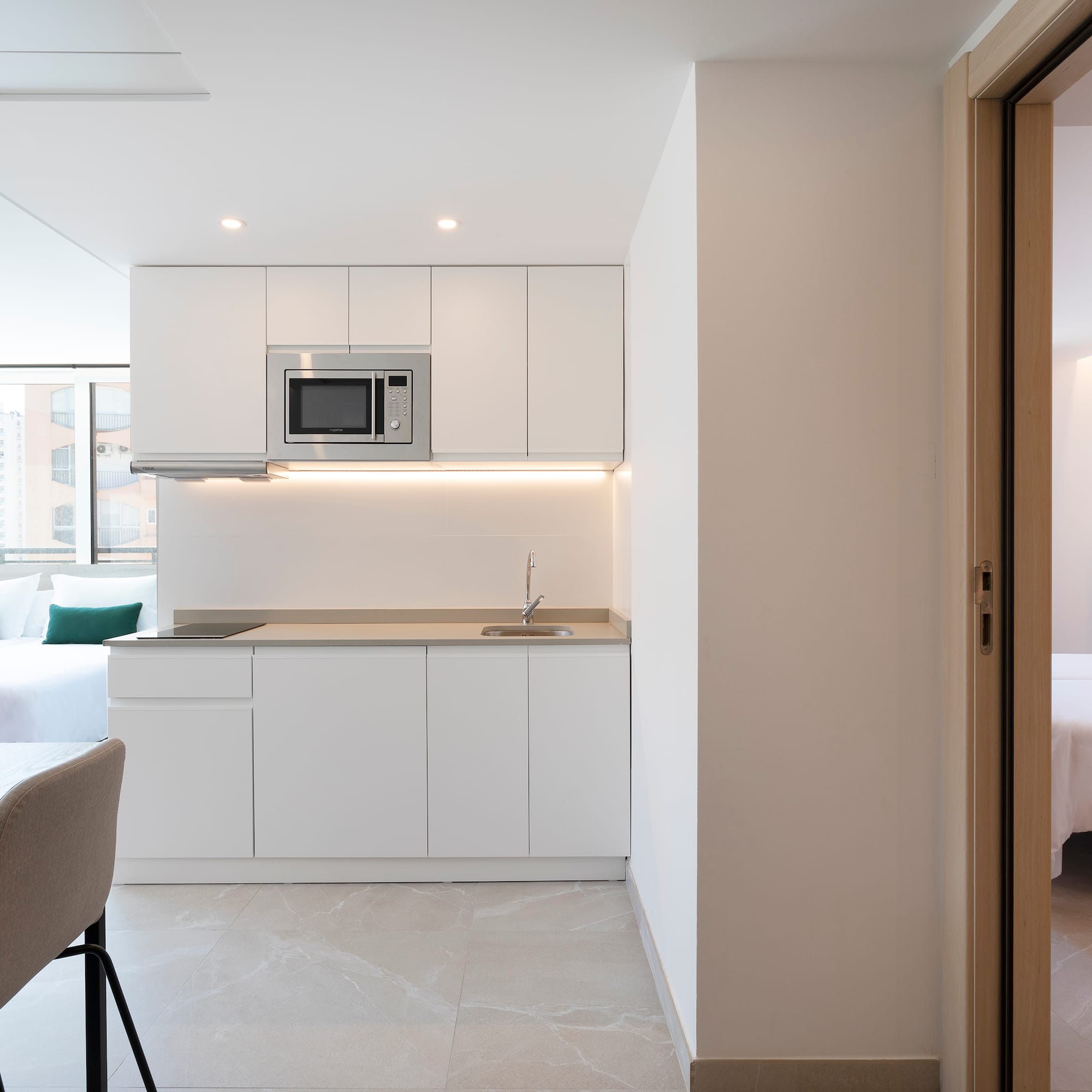 a room with a kitchen and a bed