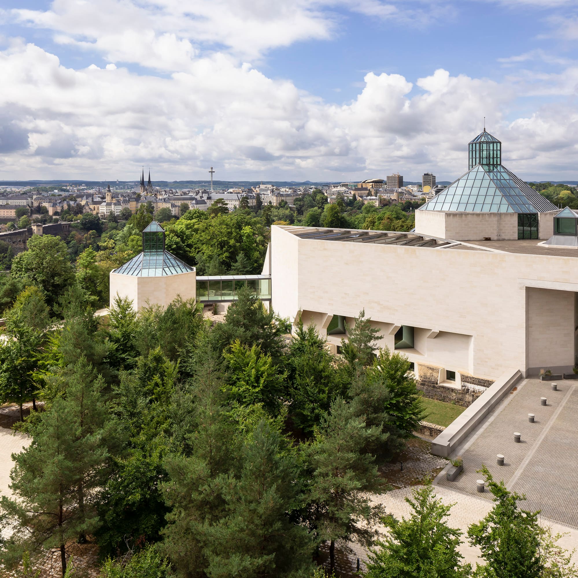 a building with trees and a city in the background
