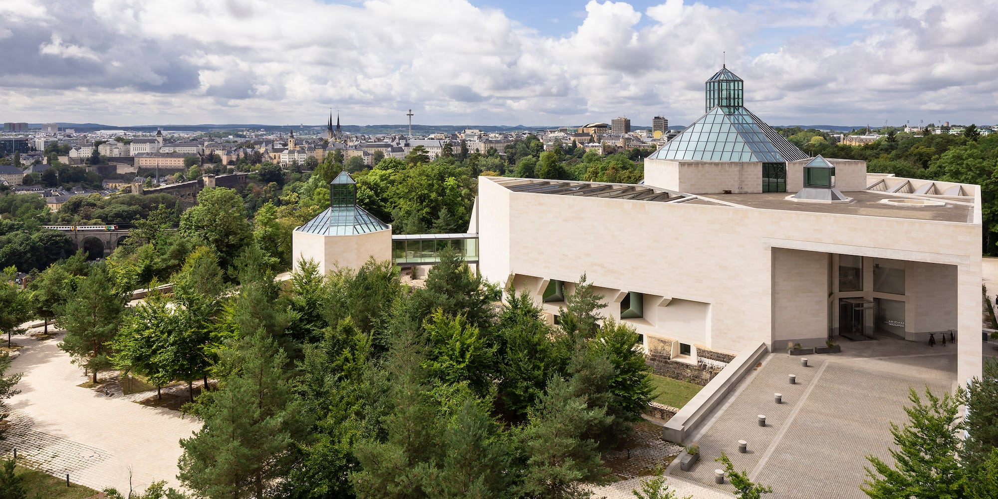 a building with trees and a city in the background