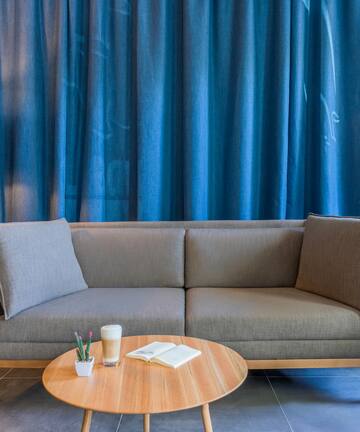 a couch and a table in front of a curtain