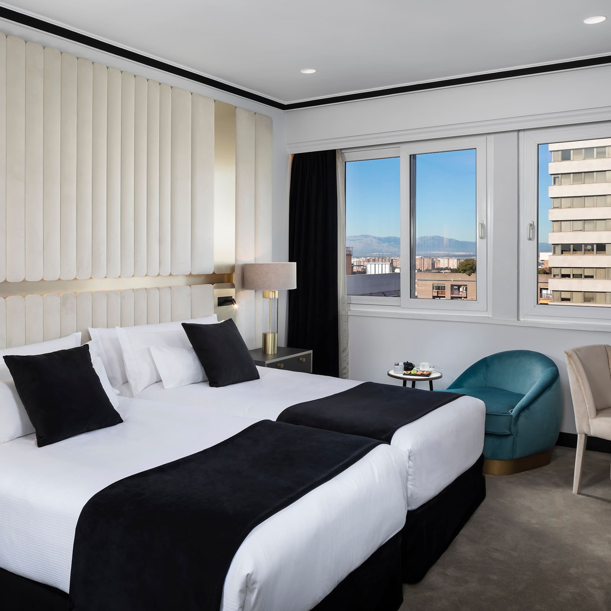 a hotel room with two beds and chairs