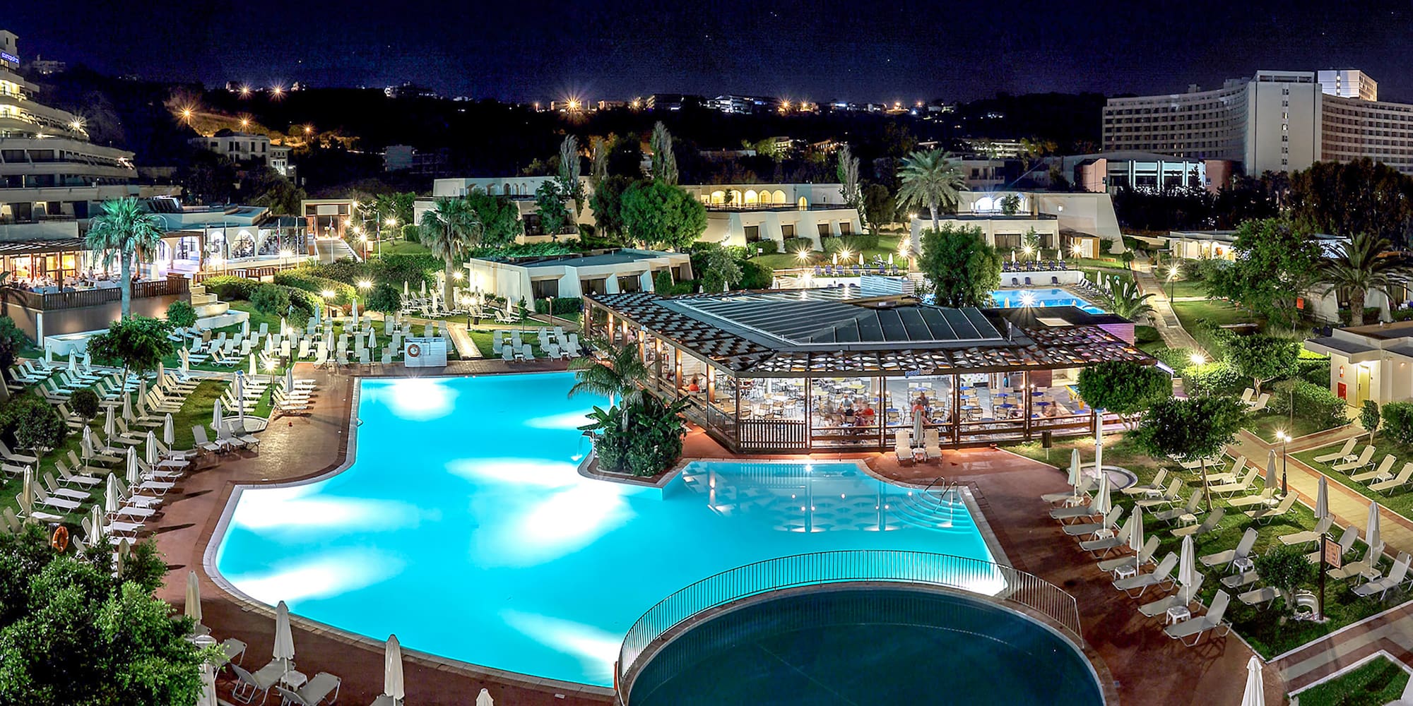 a pool with a gazebo and a building with trees and buildings