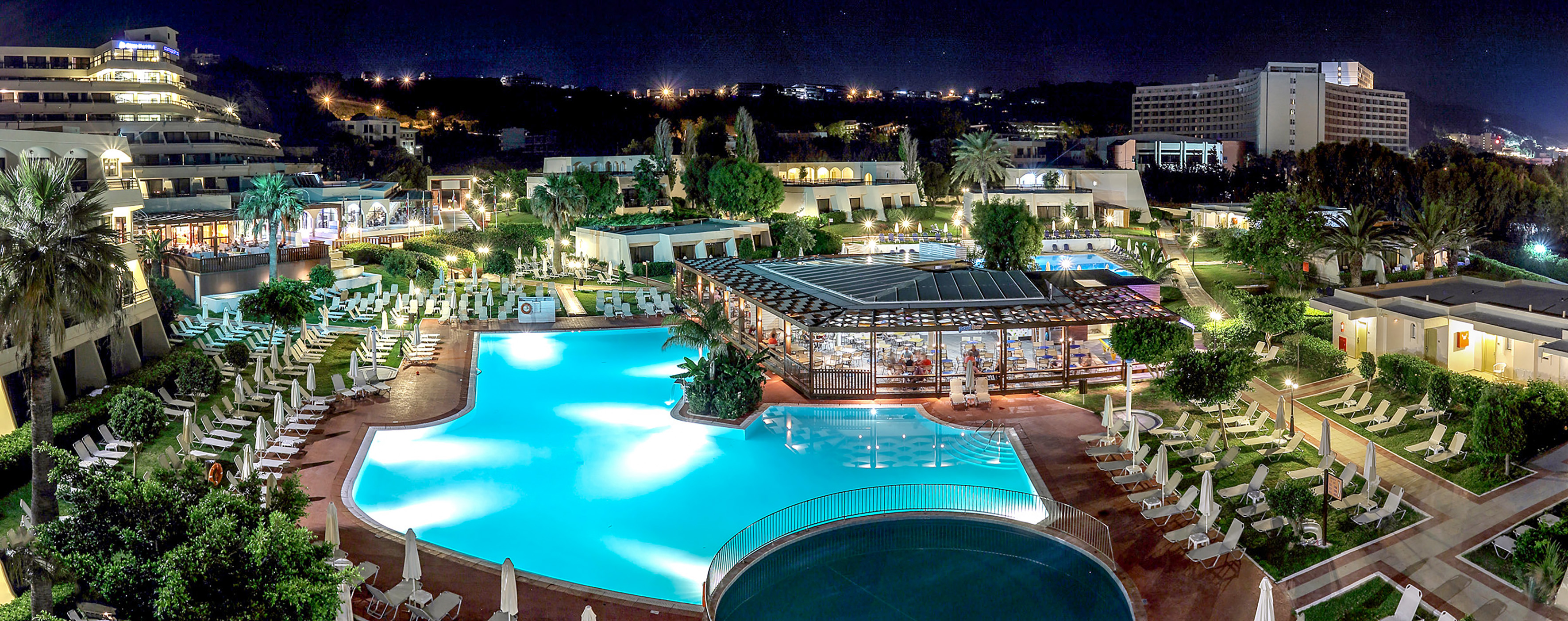 a pool with a gazebo and a building with trees and buildings