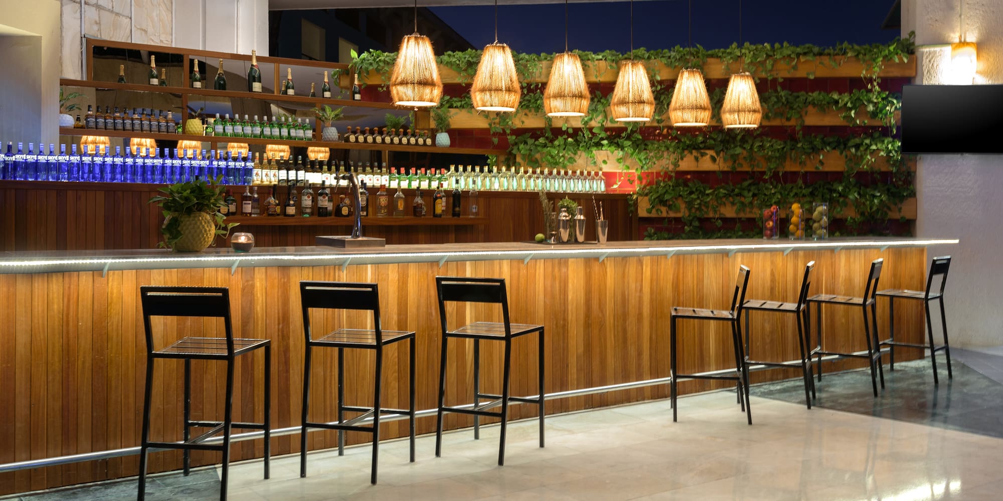 a bar with chairs and a shelf of bottles