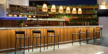 a bar with chairs and a shelf of bottles