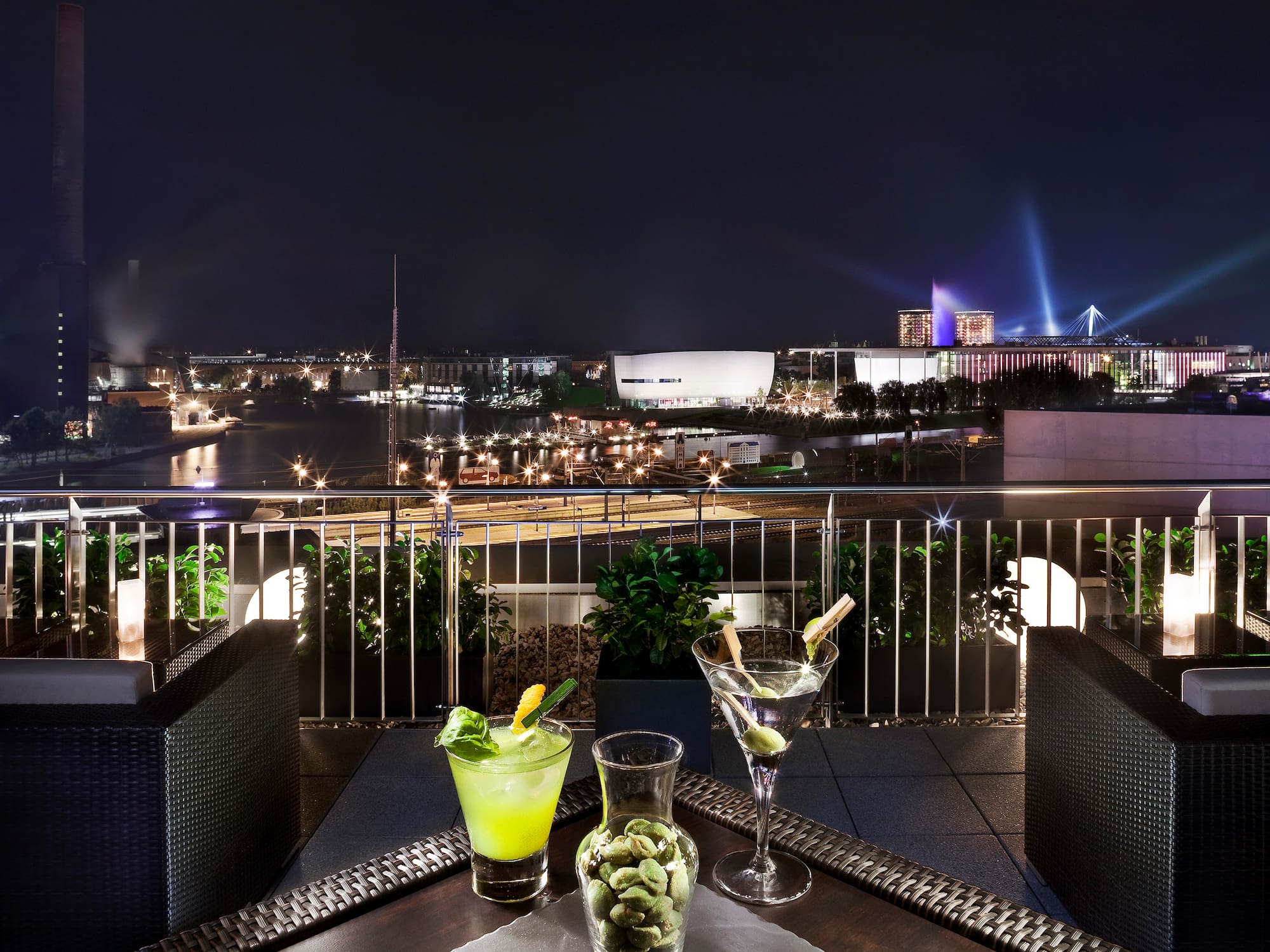 a table with drinks on it and a city view at night