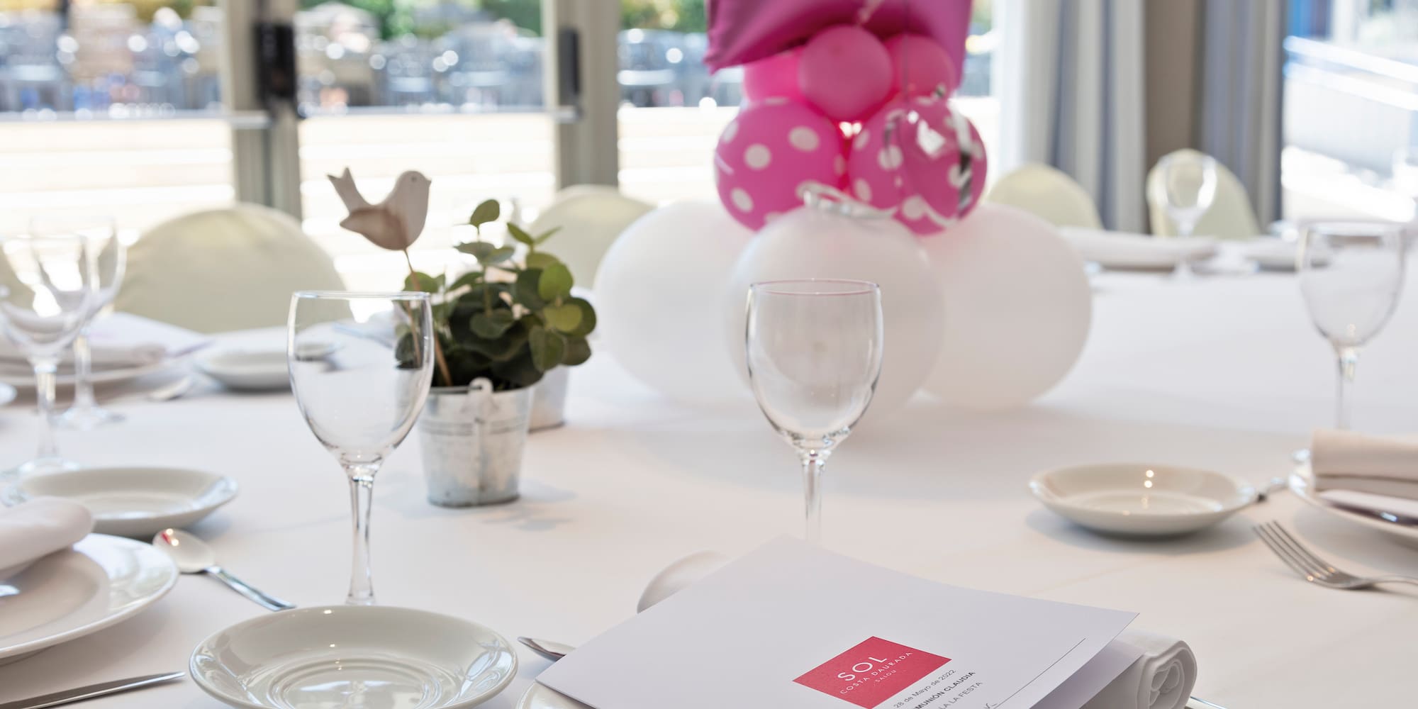 a table with plates and glasses and a balloon