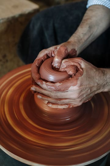 a person making a clay pot