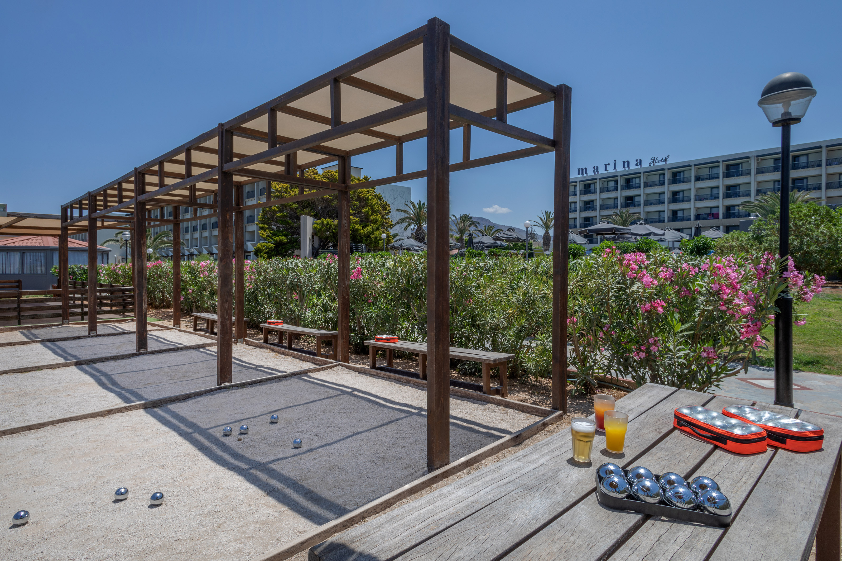 Marina Hotel bocce ball courts under a pergola, with drinks.