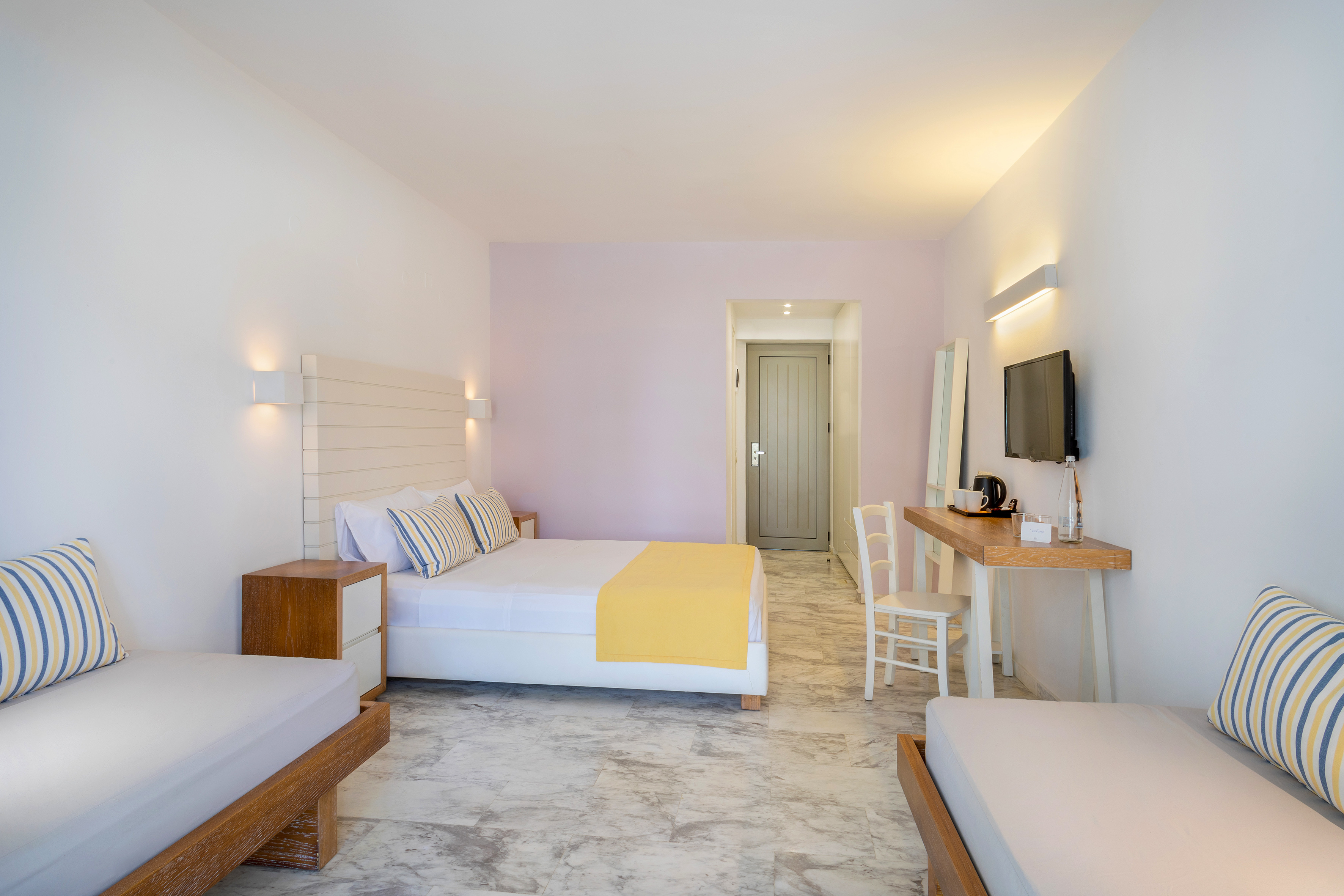 Modern hotel room with queen bed, two daybeds, white walls, and marble floor.