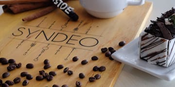 a coffee cup and a plate of coffee beans and a piece of cake