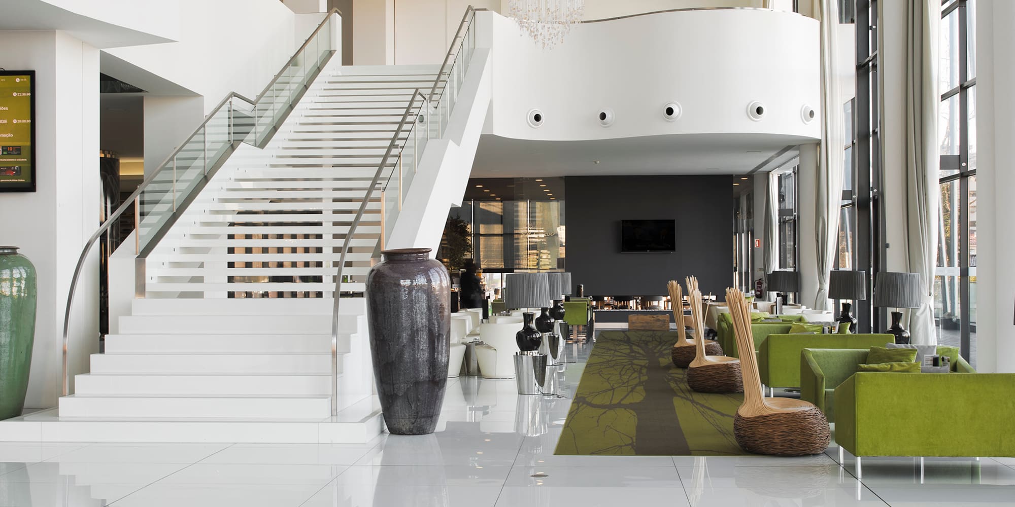 a white and green room with stairs and green chairs
