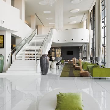 a white and green room with stairs and green chairs