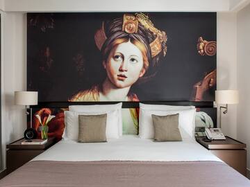 a bed with a painting on the wall