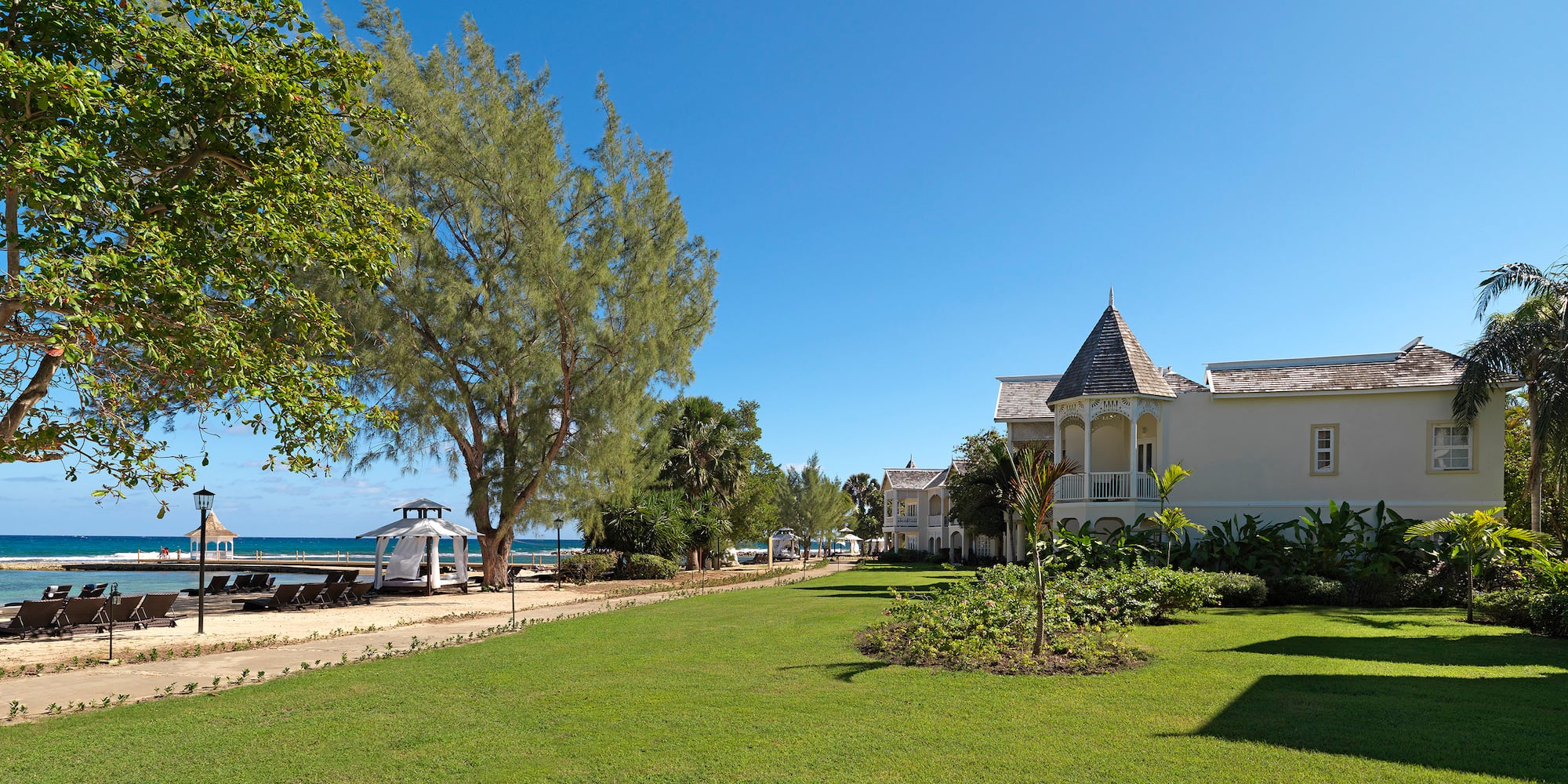 a lawn with trees and a building in the background