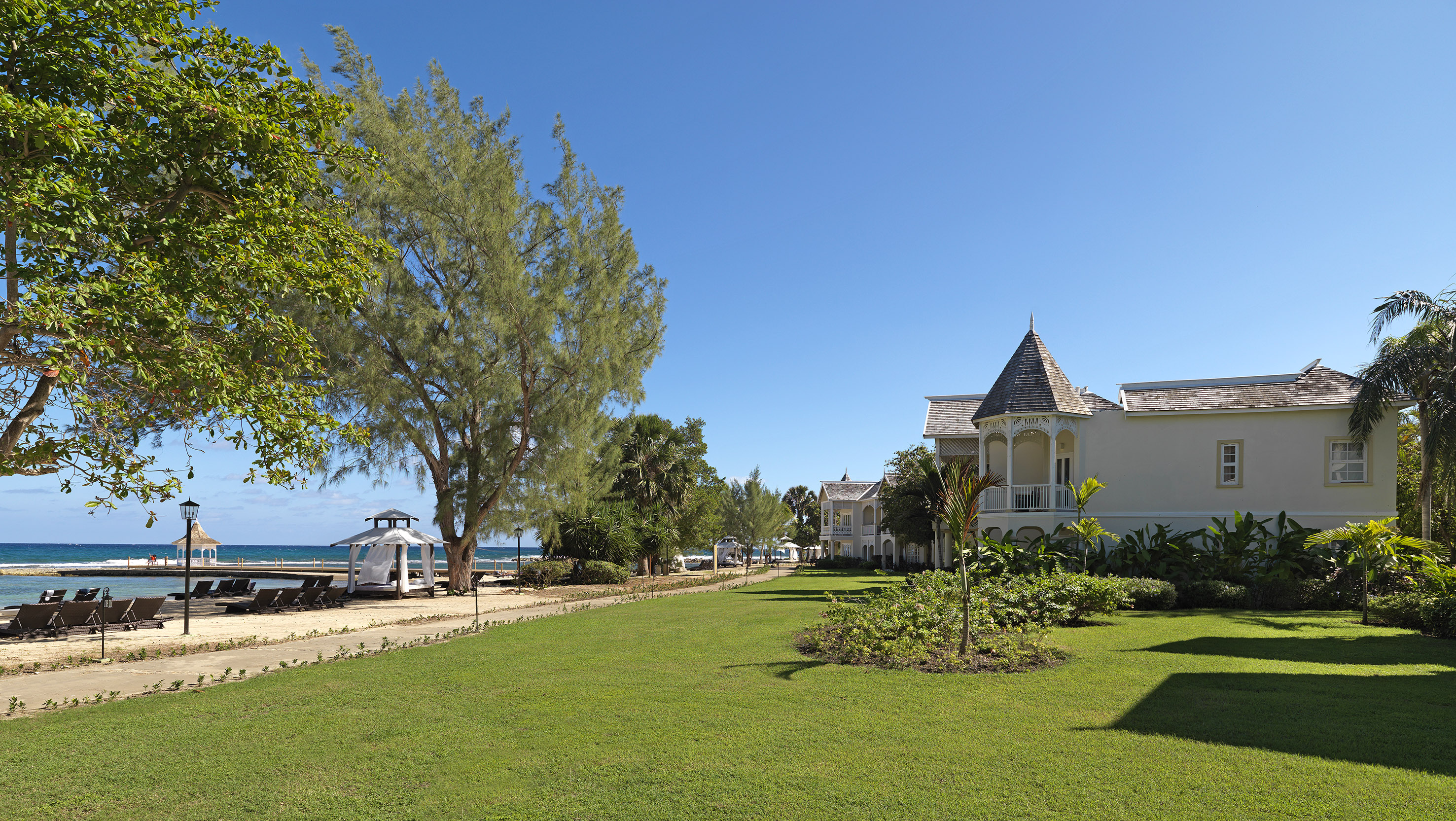 a lawn with trees and a building in the background