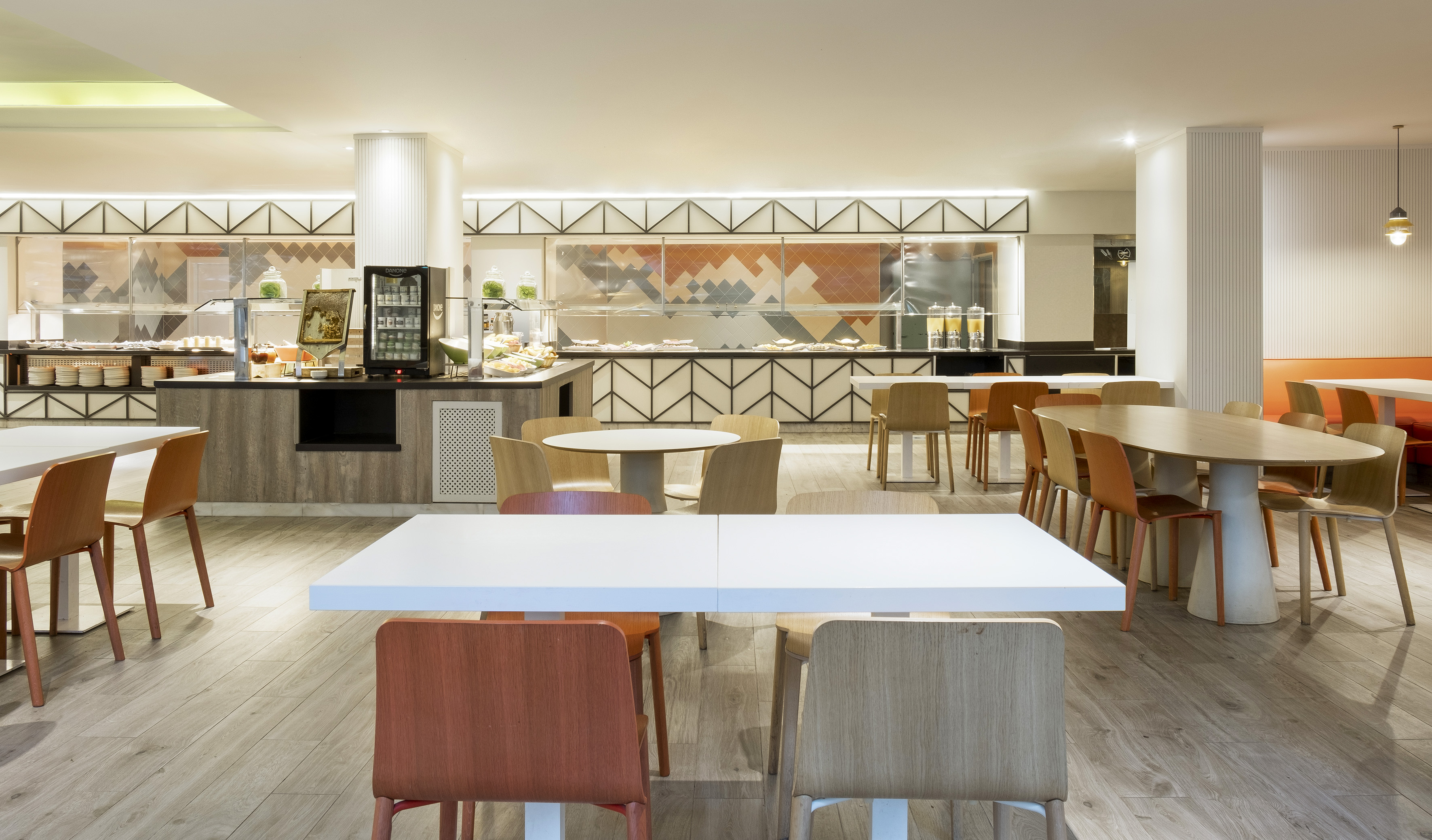 Modern hotel buffet restaurant with self-service food and dining tables.